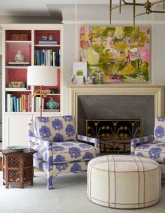 a living room filled with furniture and a fire place in front of a book shelf