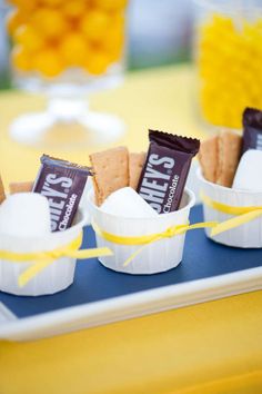 small cups filled with marshmallows and chocolate on top of a blue tray