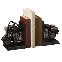 a bookend with a motorcycle on it and two books in the shape of an open book