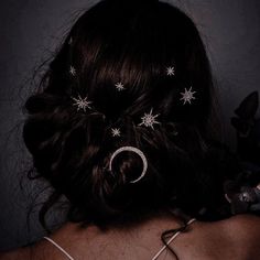 the back of a woman's head with stars and moon hair pins