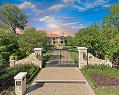 the entrance to a large home surrounded by trees