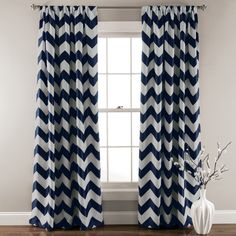 blue and white chevroned curtains in front of a window with a vase on the floor