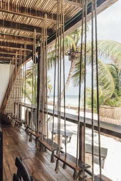 a wooden porch with swings and palm trees