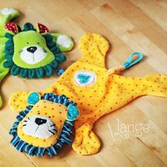 three stuffed animals laying on top of a wooden floor