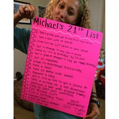 a woman holding up a pink sign with the words michael's 21st list written on it