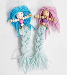 two small dolls made out of yarn on top of each other, one with a doll in the middle