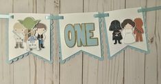 star wars themed birthday banner hanging on a wooden wall with paper cutouts and decorations