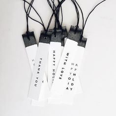 four tags that say happy birthday and have black string attached to them with words on them