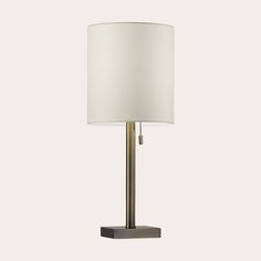 a table lamp with a white shade on it's side and a black base