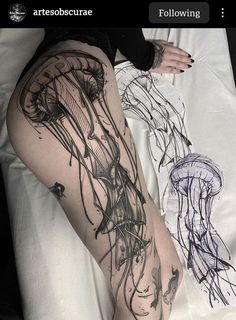 a woman laying on top of a bed next to a jellyfish and seaweed tattoo