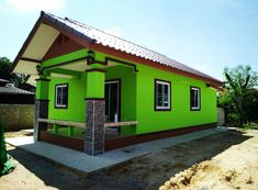 a small green house sitting on top of a dirt field