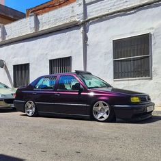 two cars parked next to each other in front of a building