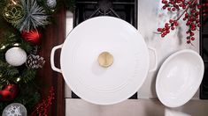 a large white casserole sitting on top of a counter next to christmas decorations