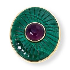 a green and gold plate with a purple stone in the center on a white background