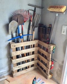 a wooden crate filled with gardening tools on top of a floor next to a wall