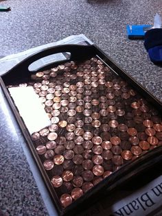 a tray filled with lots of coins sitting on top of a table