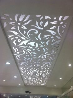 the ceiling is decorated with white flowers and swirls on it, along with other decorative items