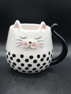 a black and white ceramic mug with a cat's face on it