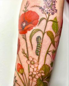 a close up of a person's arm with flowers and butterflies painted on it