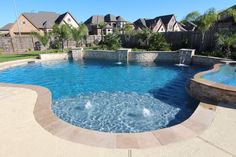 an outdoor pool with water features and landscaping