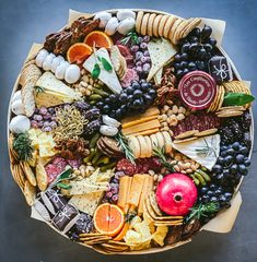 a platter filled with cheese, crackers and fruit