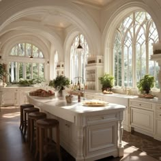 a large kitchen with lots of windows and white counter tops, along with wooden stools