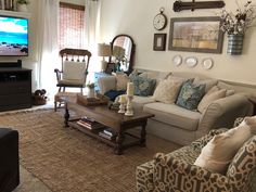 a living room filled with furniture and a flat screen tv mounted to the side of a wall