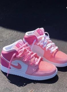 a pair of pink and white shoes on the ground