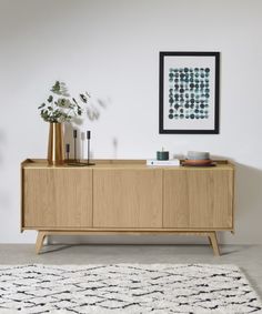 the sideboard is made from wood and has a white rug on top of it