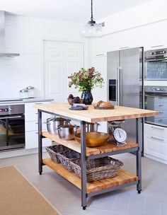 a kitchen island with baskets on it in front of an oven