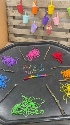 a black tray topped with lots of different colored yarn and scissors on top of it