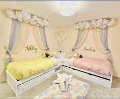 two twin beds in a girls bedroom decorated with rainbows and clouds on the wall