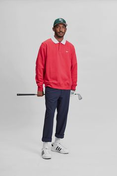 a man in a red sweater and blue pants holding a golf club