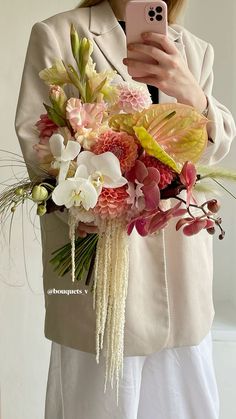 a woman is taking a selfie with her cell phone while holding a flower bouquet