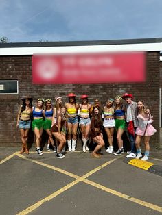 a group of young women standing next to each other in front of a brick building