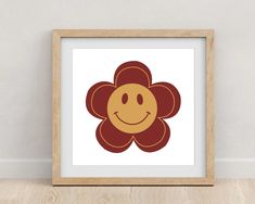 a flower with a smiley face drawn on it's side in a wooden frame