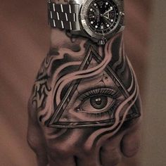 a man's hand with an all seeing eye tattoo on it and a wrist watch