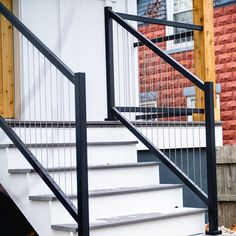 a cat sitting on the steps of a house