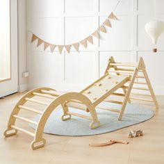 a child's wooden rocking chair on the floor in front of a white wall