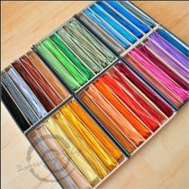 a box filled with lots of different colors of thread on top of a wooden table