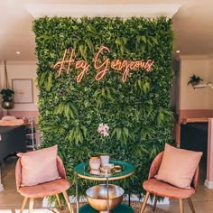 two chairs and a table in front of a green wall with the words happy congrat written on it