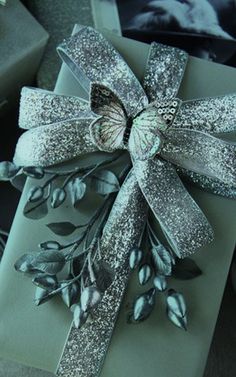 a gift wrapped in silver paper with a bow