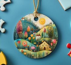 an ornament hanging from a string on a blue surface with puzzle pieces surrounding it