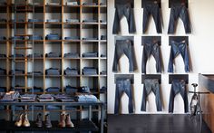 there are many pairs of jeans hanging on the wall in front of shelves with shoes