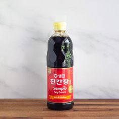 a bottle of soy sauce sitting on top of a wooden table