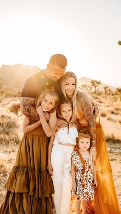 a family posing for a photo in the desert with sun shining down on their heads