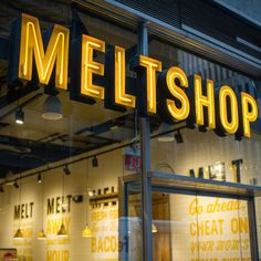 a neon sign that reads melt shop on the front of a storefront with yellow lettering