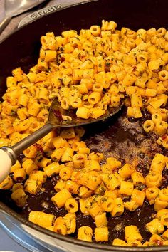 a pan filled with macaroni and cheese on top of a stove