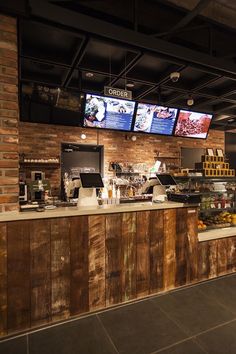 the inside of a fast food restaurant with menus on the wall and televisions above