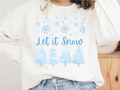 a woman wearing a sweatshirt that says let it snow